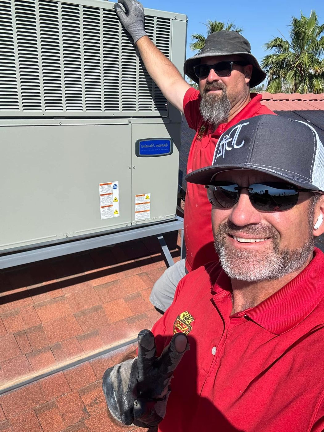 Two Noble technicians beside a newly installed rooftop unit