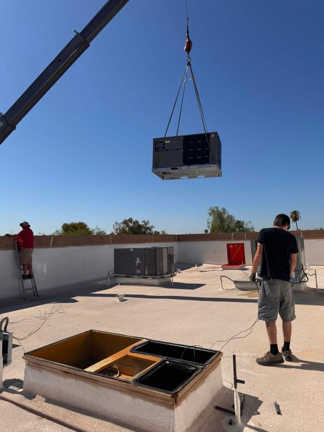 A new rooftop unit being lifted into place by crane