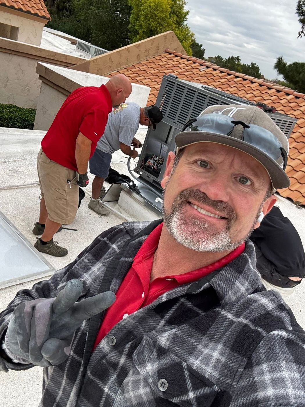 Noble technician on a tile-roof job with the crew working behind him