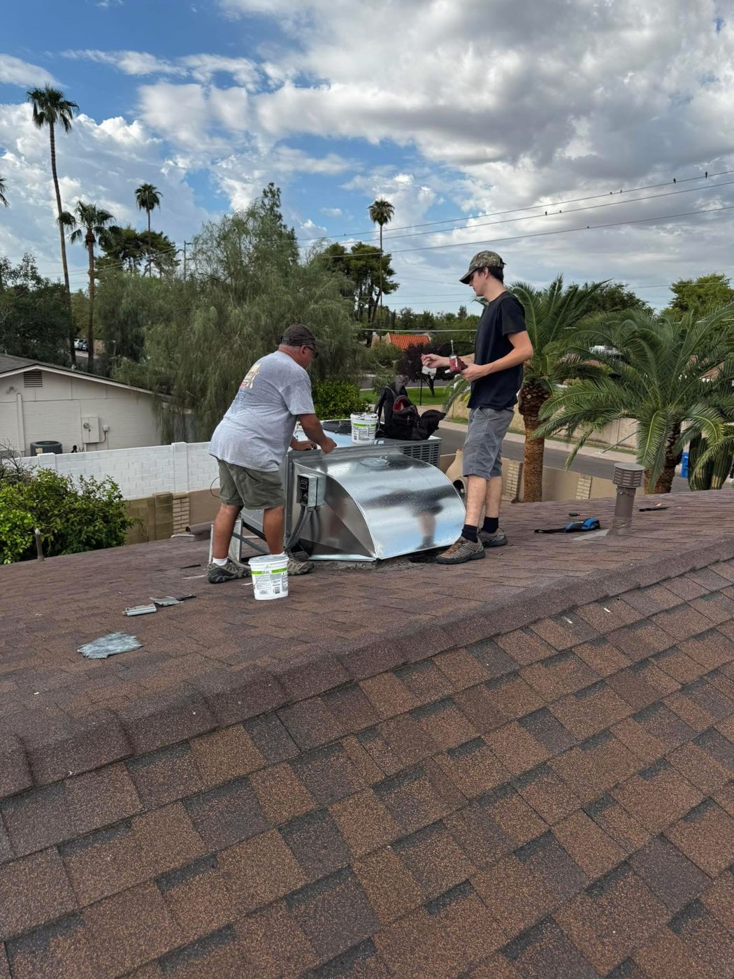 Noble crew installing a rooftop unit on a shingle roof